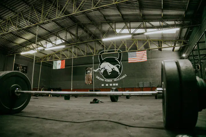 Loaded barbell on the floor of a large warehouse strength gym