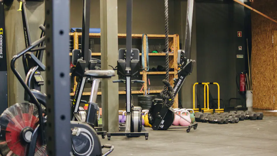 Conditioning gym with an air bike, a rower, a rig and kettlebells