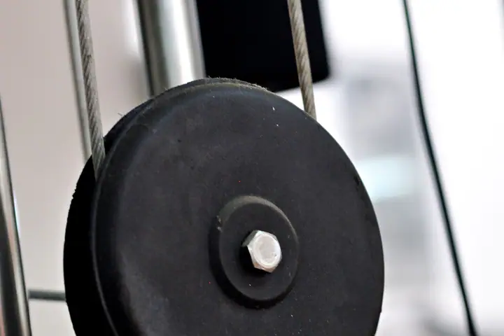 Close-up of the pulley wheels and cable of a gym machine