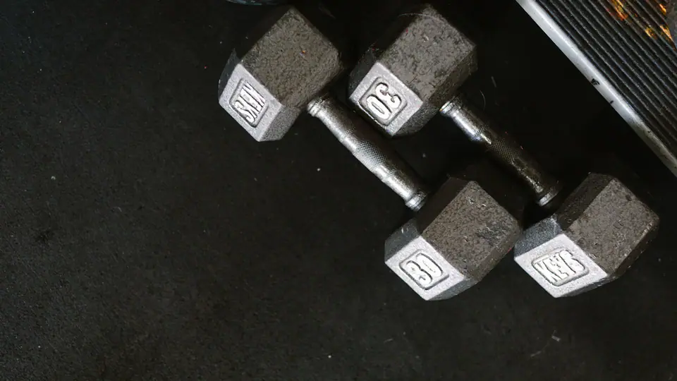 Two pairs of hexagonal dumbbells on a rubber floor, seen from above