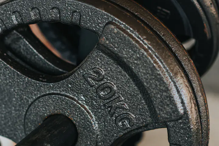 Close-up of a 20 kg cast-iron weight plate on a storage peg