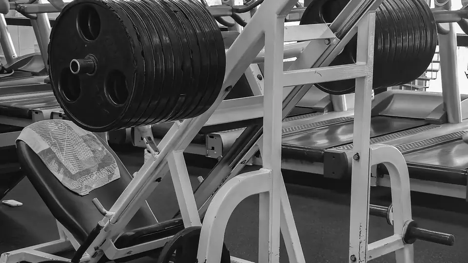 Black-and-white photo of a plate-loaded leg press machine
