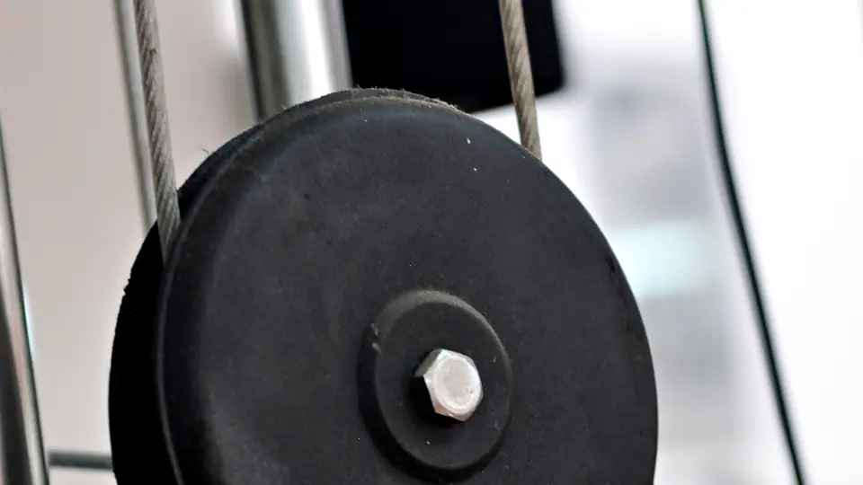 Close-up of the pulley wheels and cable of a gym machine