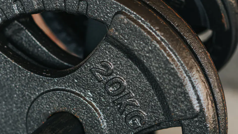 Close-up of a 20 kg cast-iron weight plate on a storage peg