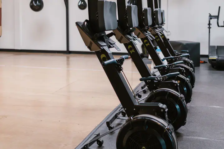 Line of upright rowing machines in a training hall