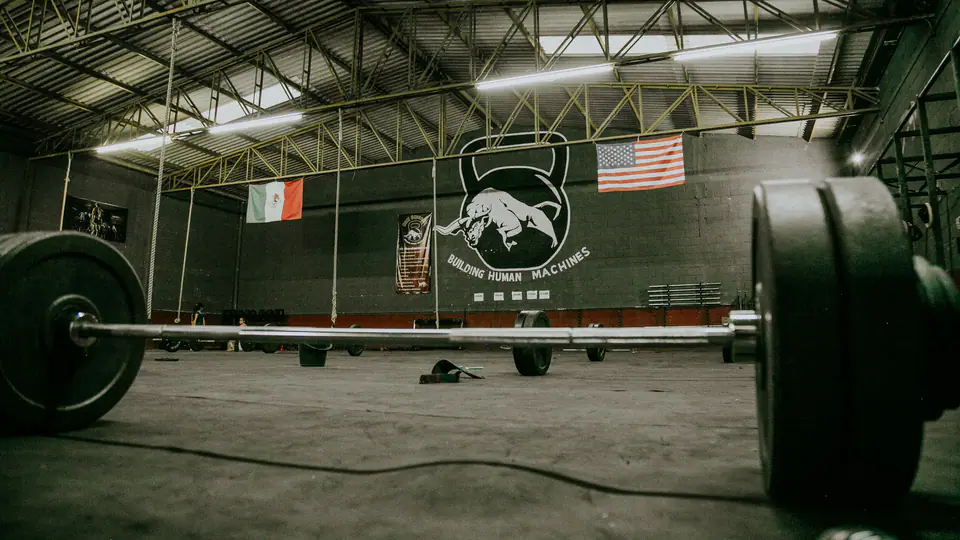 Loaded barbell on the floor of a large warehouse strength gym