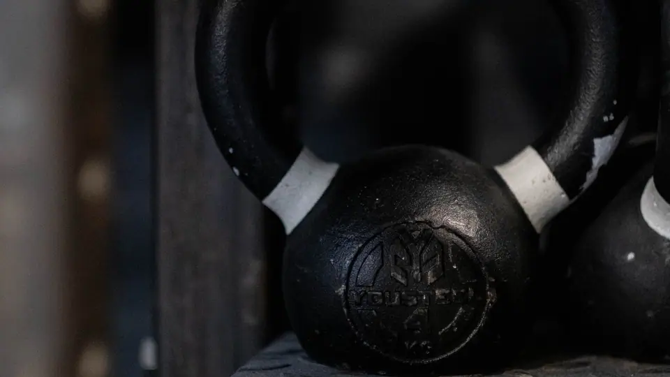 Cast-iron kettlebells on a dark wooden shelf