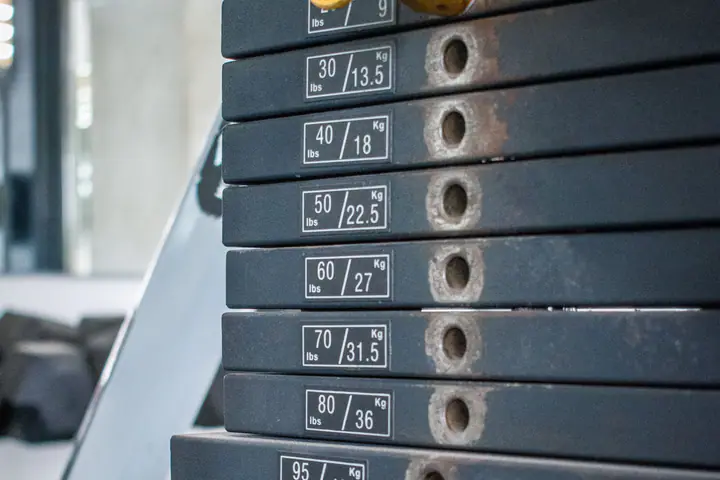 Weight stack of a cable machine with the selector pin set in one of the numbered plates